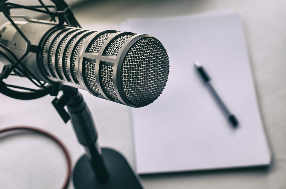 Microphone with pen and notebook in background